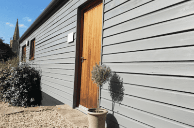 Image showing the outside of a wood cladded building with a wooden door and some plants - Wessex Commercial Solutions Xero Accountants in Exeter and Yeovil